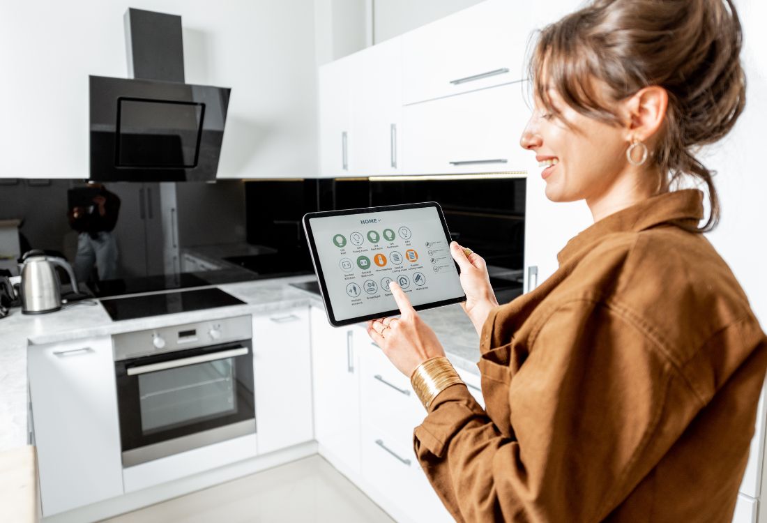 A woman controls kitchen appliances and her solar readings through the solar batteries that have revolutionised her household.